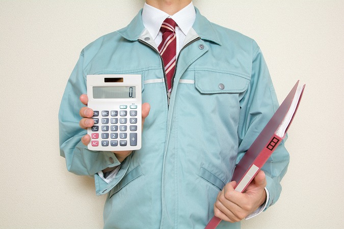 電卓とファイルもつ作業員